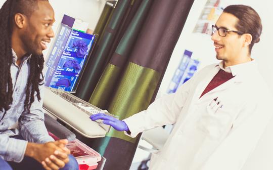 White male doctor and African American patient in an exam room