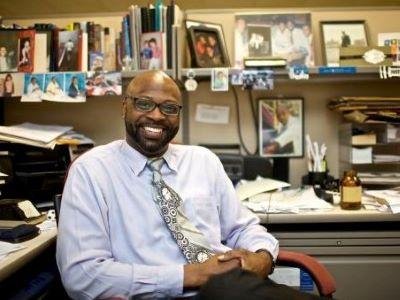 man in tie at desk smiling